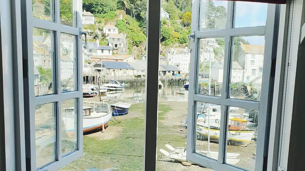 Open window with a stunning view onto a fishing harbour in Cornwall
